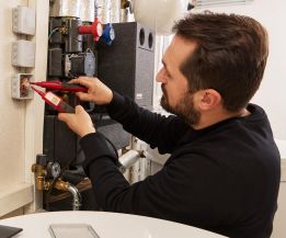 SHK-Fachhandwerker von WEME Heizung & Sanitär misst elektrische Werte an einer Heizungsanlage, prüft Anschlüsse und Komponenten in einem Technikraum