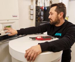 SHK-Fachhandwerker von WEME Heizung & Sanitär bedient die Steuerung einer Heizungsanlage, prüft Einstellungen an einem Heizgerät in einem Technikraum