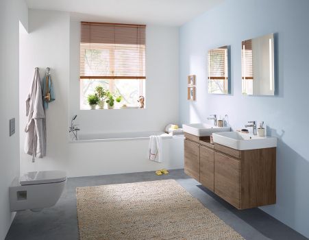 Helles Badezimmer mit Badewanne, Doppelwaschtisch aus Holz, wandhängendem WC und natürlichem Tageslicht