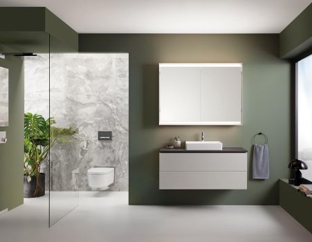 Modern gestaltetes Badezimmer mit bodengleicher Dusche, Waschtisch und Geberit AquaClean Mera Dusch-WC in ruhigen Grüntönen